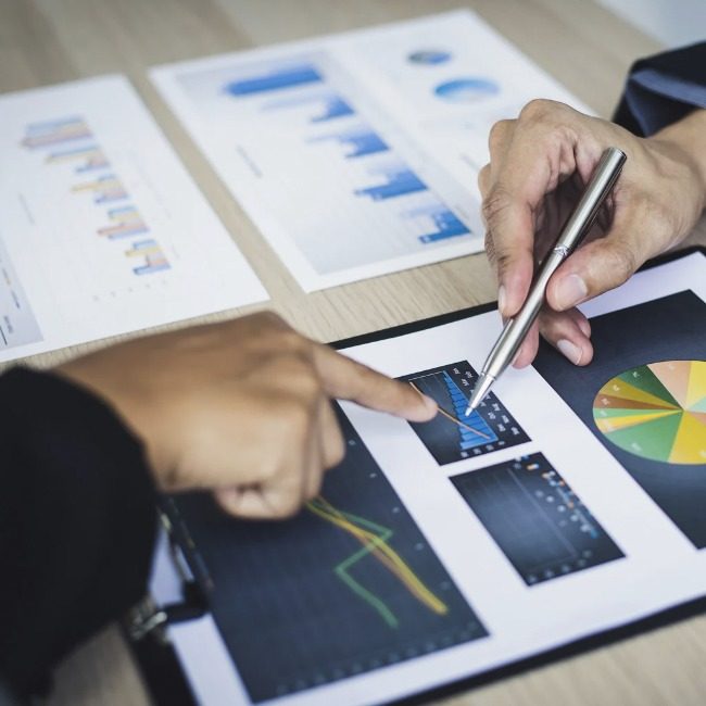 Hands reviewing printed strategy charts on a desk